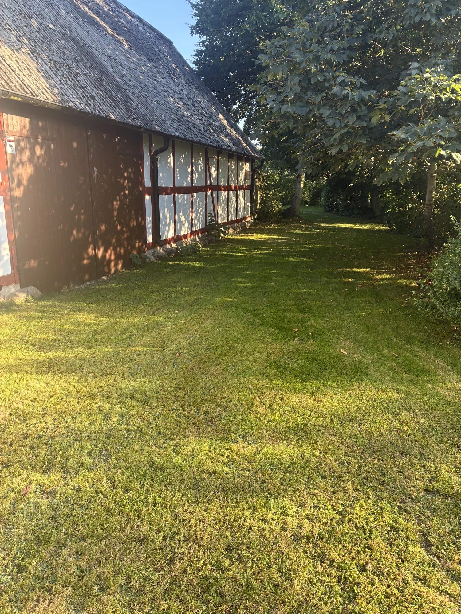 Korsvirkesbyggnad och grönskande trädgård vid Solgläntan.